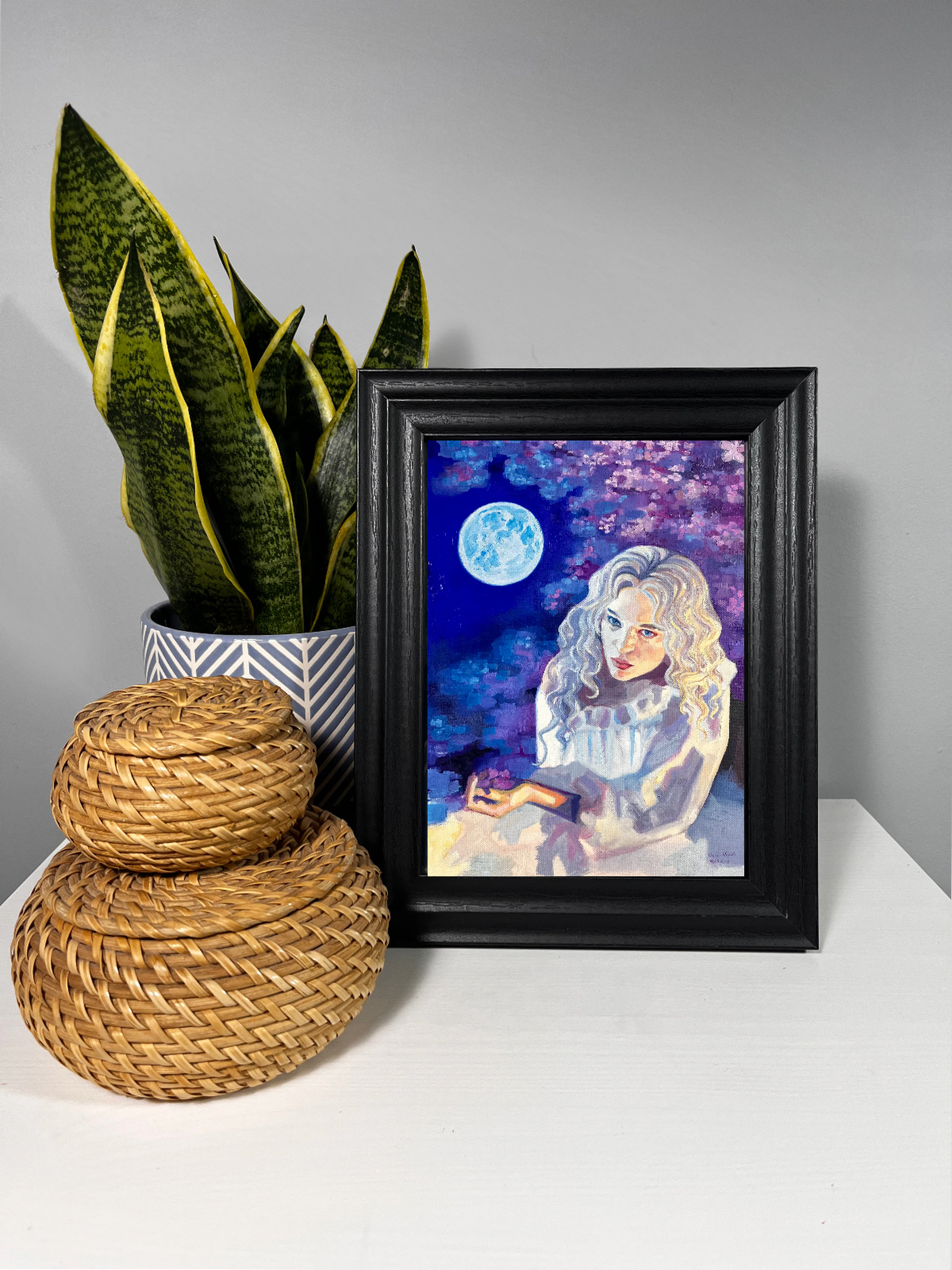 Lumen – blonde woman beneath a full moon and cherry blossoms in a blue-violet night landscape