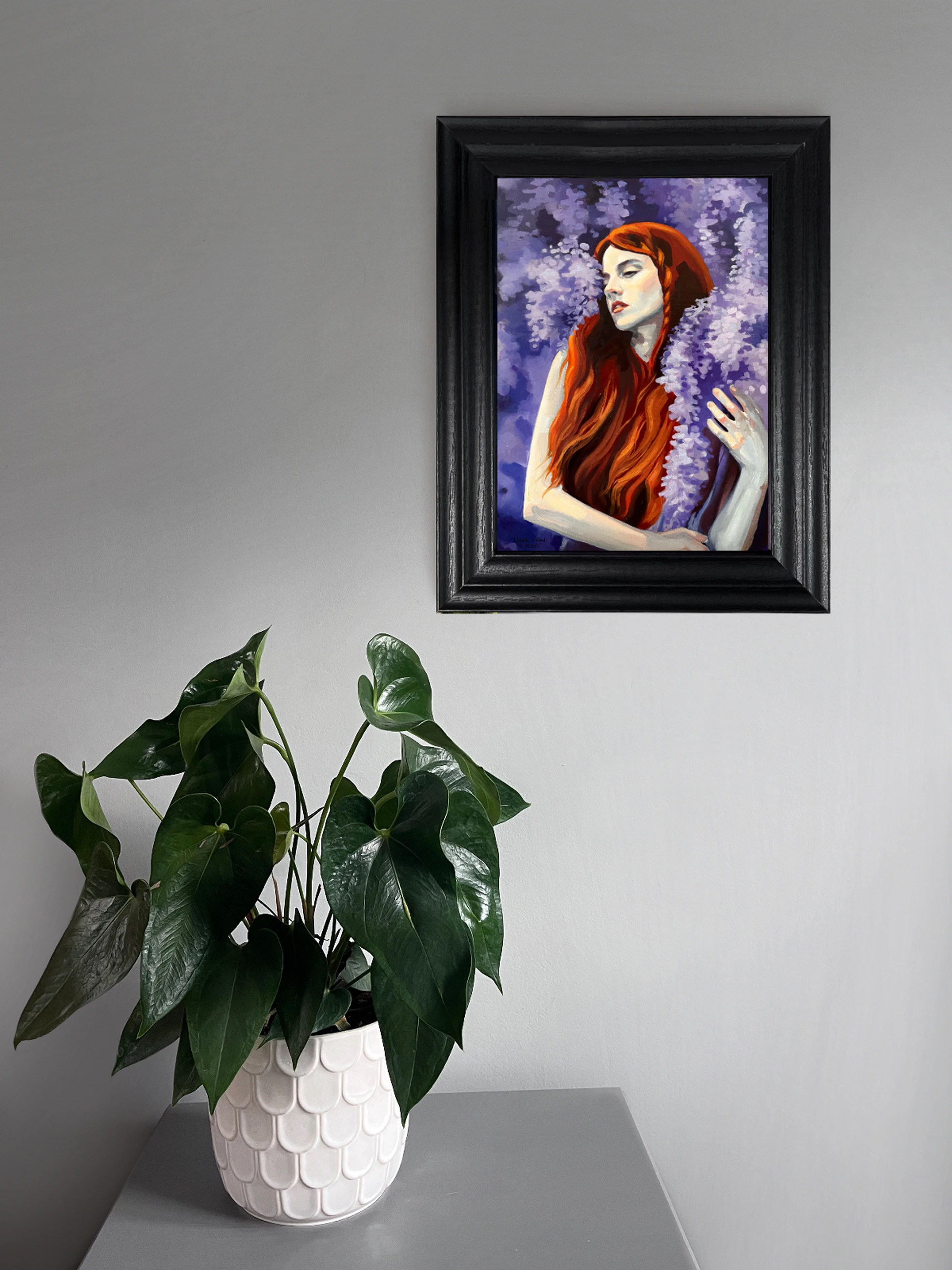 Fine art print of a red-haired woman with closed eyes surrounded by cascading violet wisteria blossoms