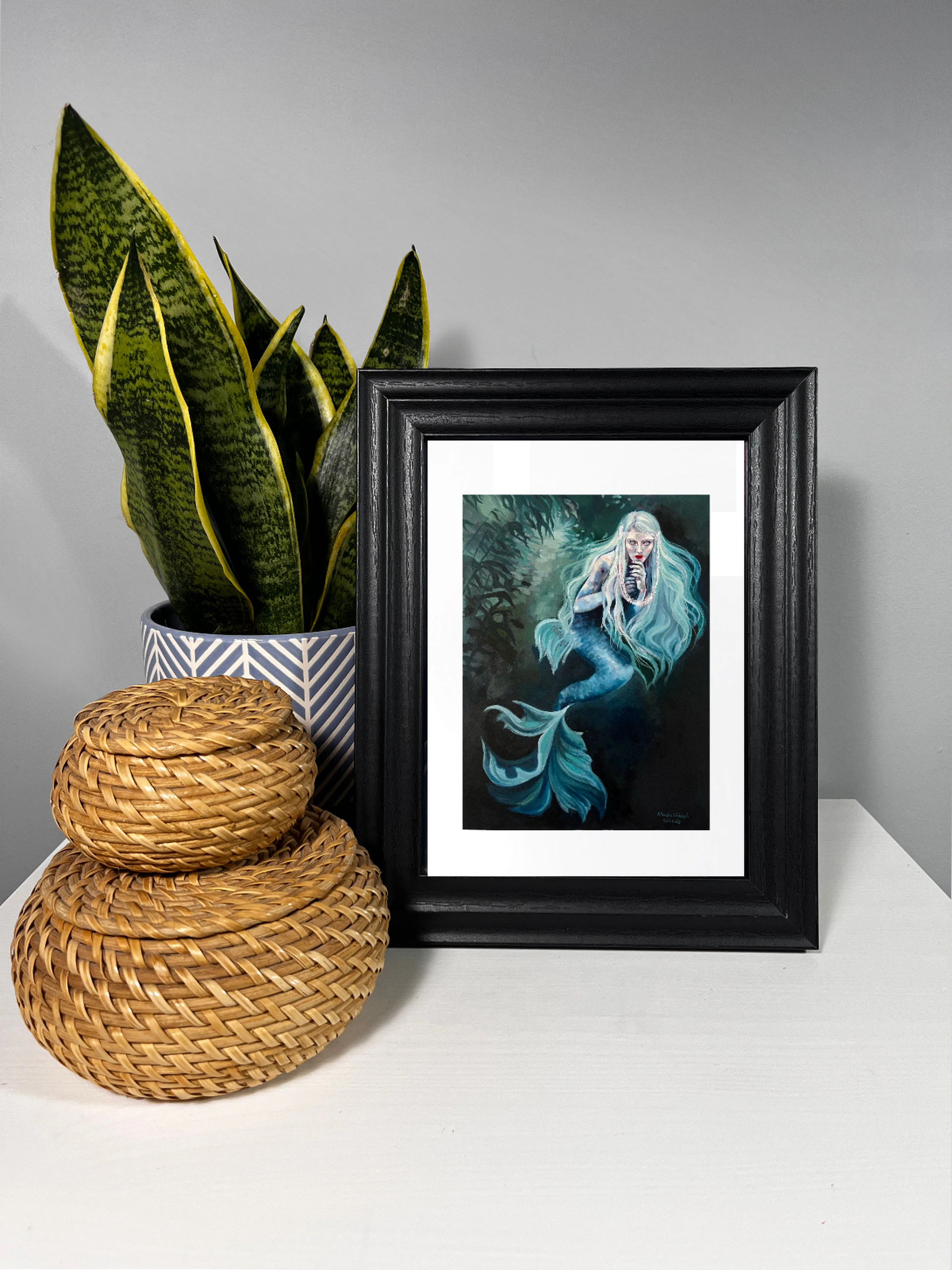 White-haired mermaid among dark underwater plants and small fish in cool turquoise water